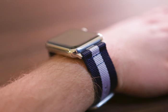 Kép: Apple Watch a kék-fehér-kék csíkos szíjjal felvéve a csuklónkra.
