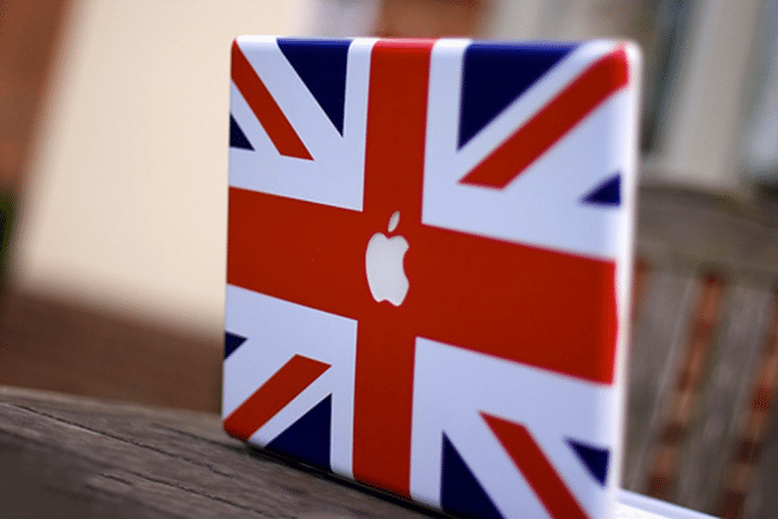 Borítókép: Brit zászlós matricával befedett MacBook, ahol a zászló közepén a fehér alma szabadon van hagyva.