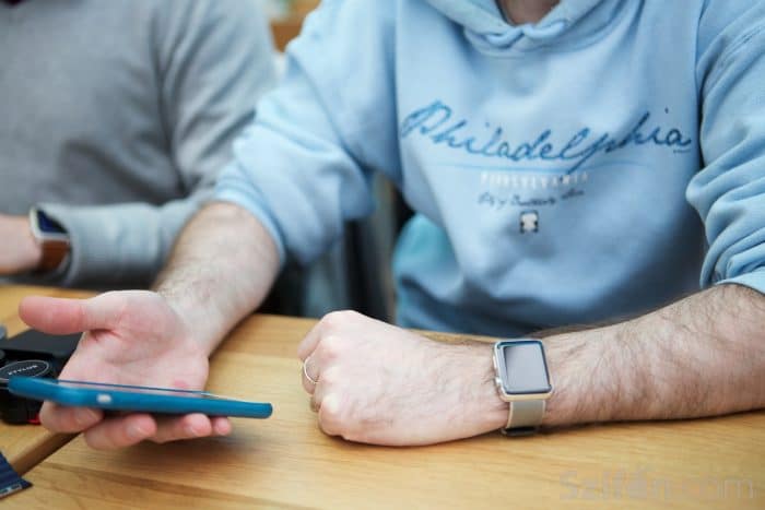 Kép: Apple Watch az asztalnál ülve egyikünk kezén, másik kézben az iPhone-nal.