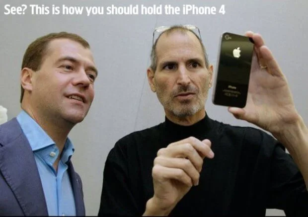 Steve Jobs Dimitri Medvegyevnek mutatja az iPhone 4-et, amit mindössze 4 ujjával tart a készülék tetejét és alját fogva, a képen felirattal: "See? This is how you should hold the iPhone 4. (Látja? Na így kell fogni az iPhone 4-et!)".