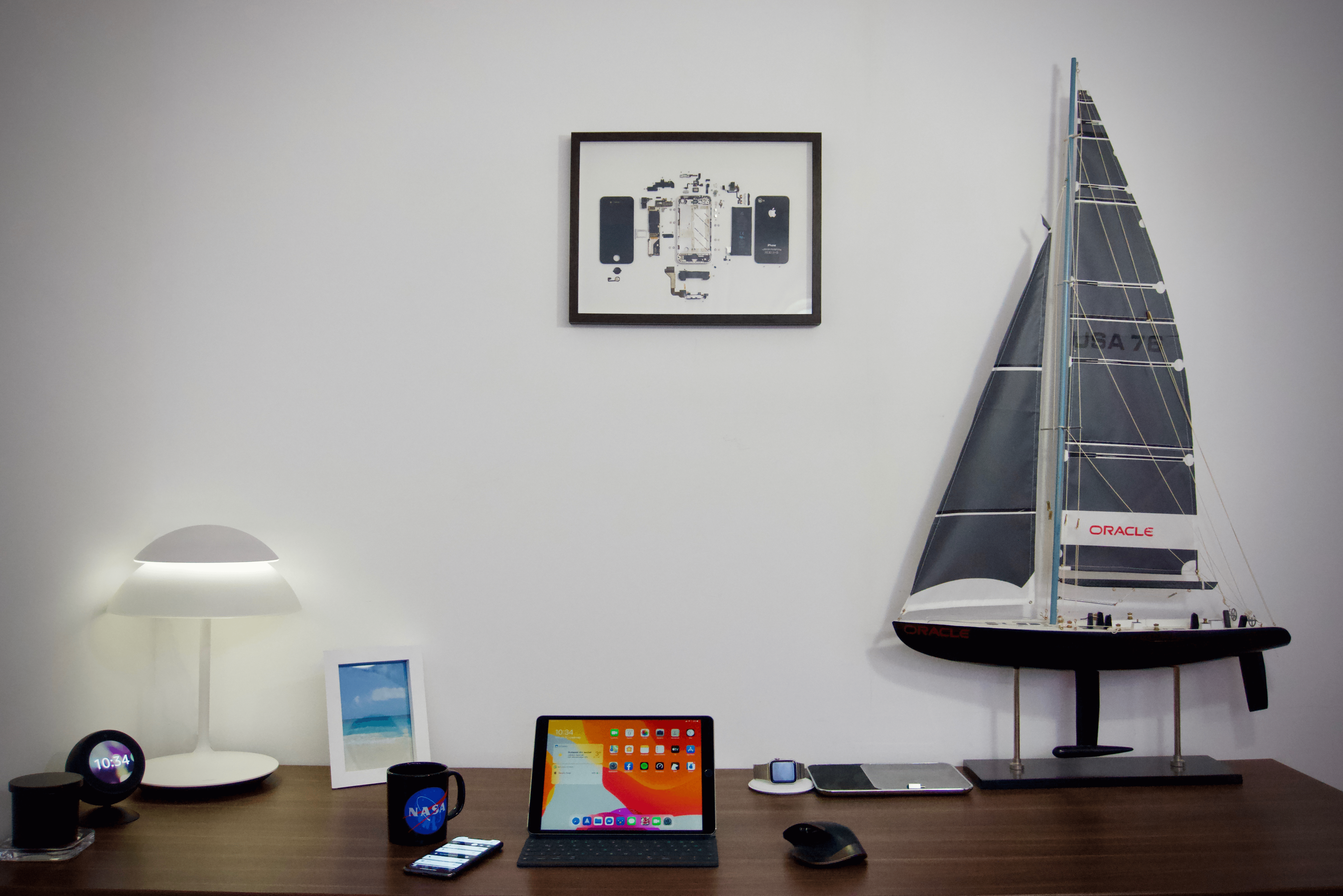 Egy fekete iPhone 4 képkeretben, íróasztal fölött a falon.