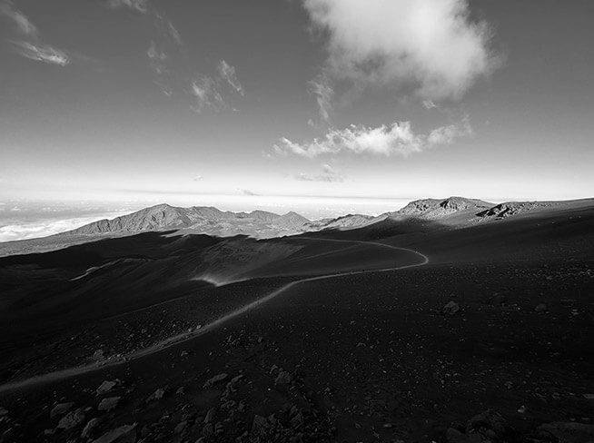Hegyvidéki tájat ábrázoló fekete-fehér fénykép, amely az ultraszéles látószögű kamera 0,5-szörös zoomjával készült.